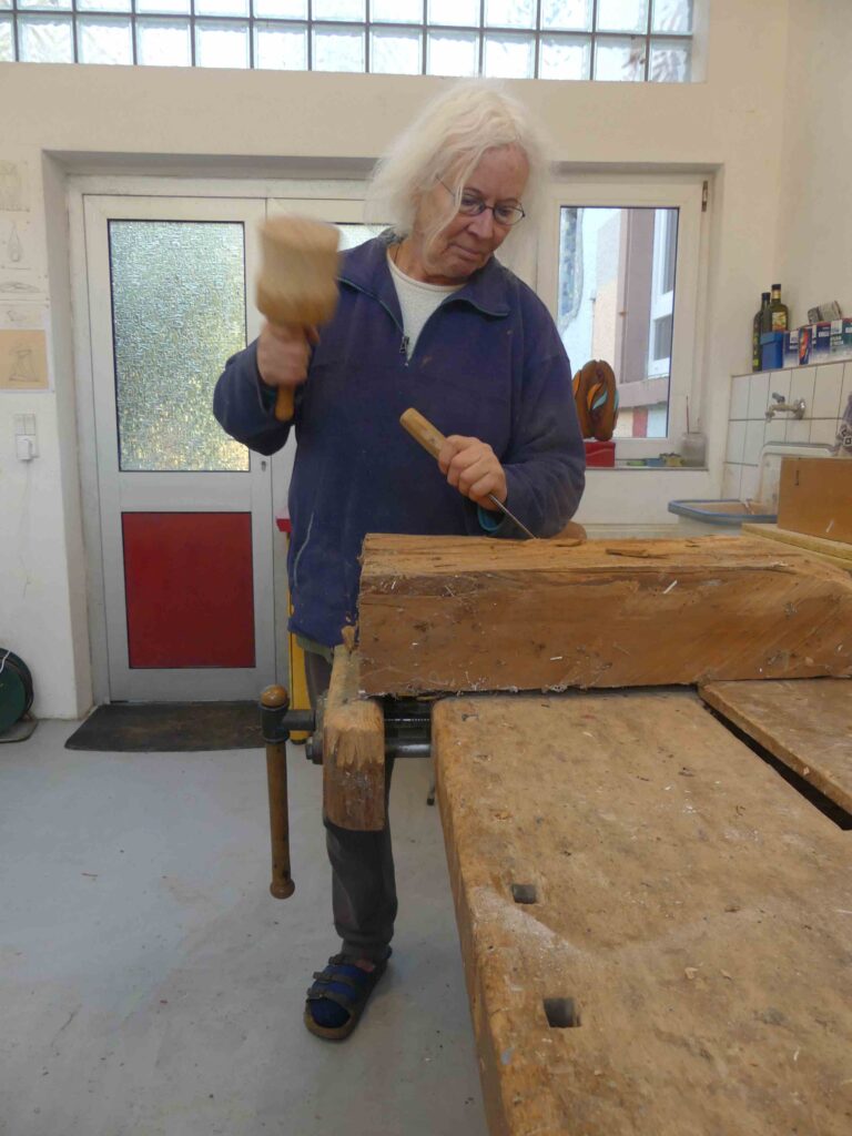 Hedda Brahms arbeitet an Holz Skulptur