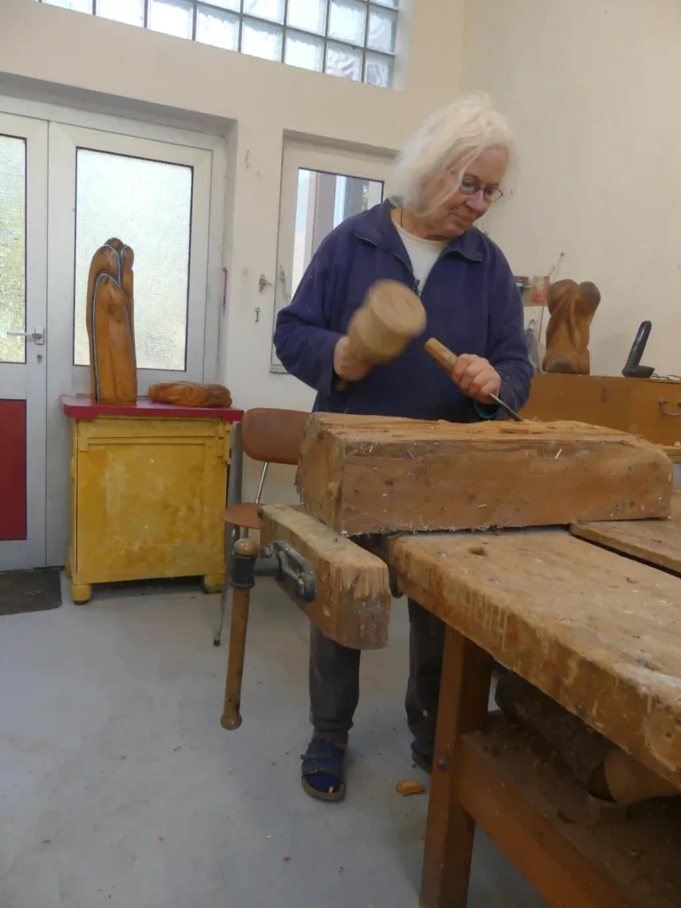 Hedda in der werkstatt dabei eine Holzskulptur zu fertigen